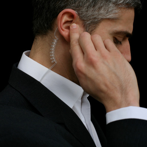 Mid adult business man wearing hands-free device, close-up